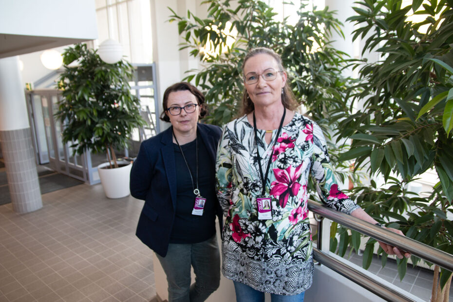 Ekaterina ja Tuija TAKKin keskustakampuksen aulassa, Tuija pitää porraskaiteesta kiinni. Taustalla viherkasveja.