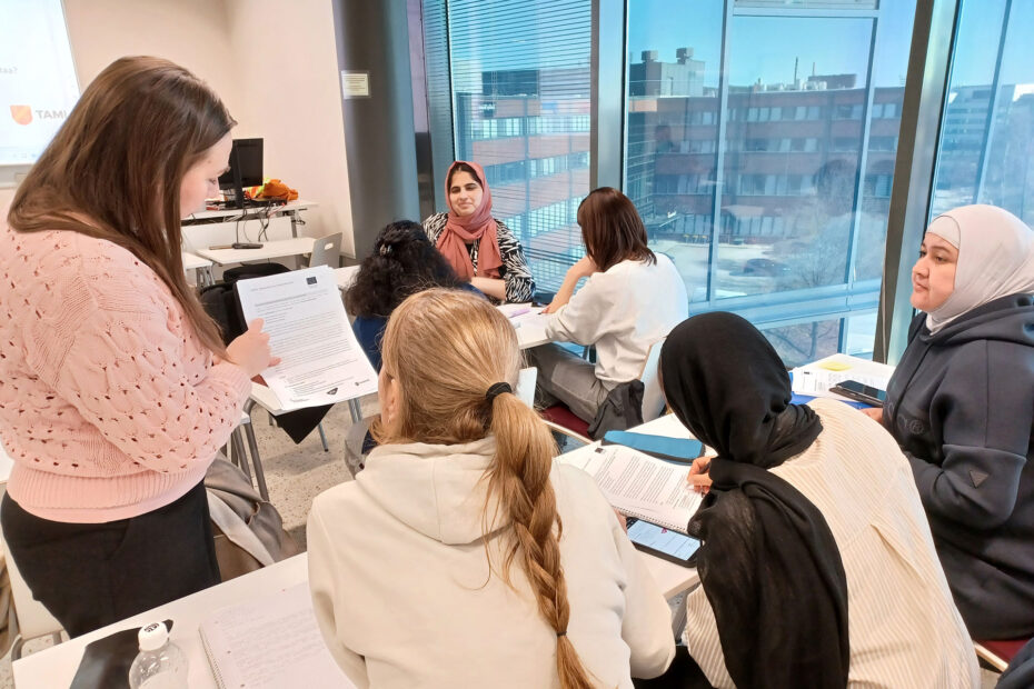 Opiskelijat opiskelemassa MOPO-hankkeen pilottipäivässä luokassa valkoisten pöytien ääressä, yhdellä seinustalla suuret ikkunat.